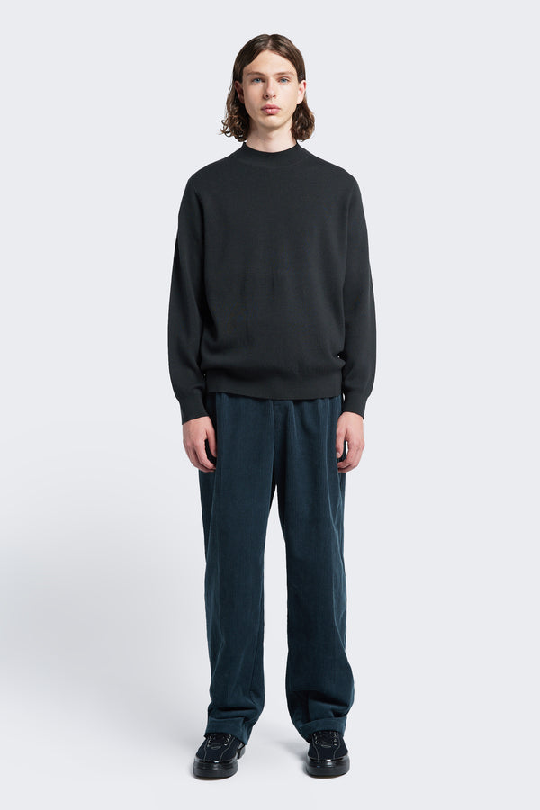 The Dose Merino Sweater knitted in a fine Merino wool in charcoal, this mock-neck style is finished with a 1x1 rib hemline and cuffs.