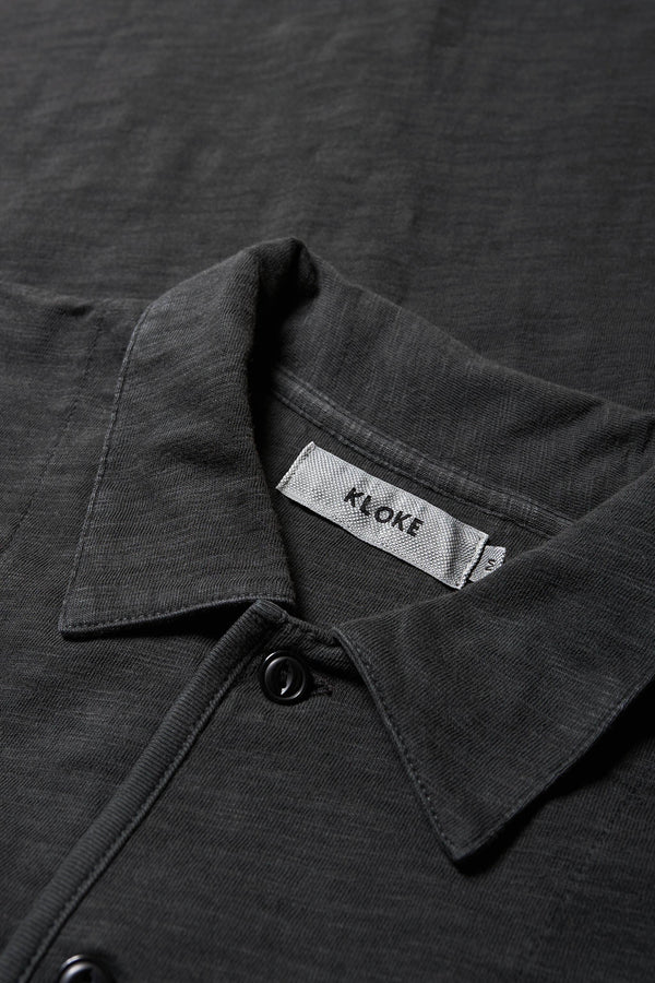 Close up details of The Tectonic Shirt in vintage black, a classic boxy fit T-Shirt made from 100% cotton garment dyed jersey with a reinforced back yoke. Available in 5 sizes.