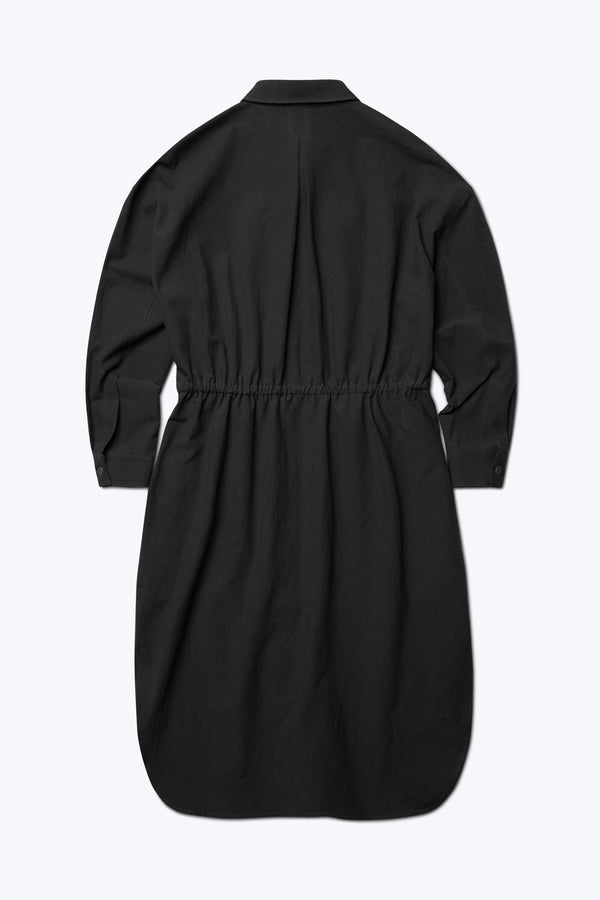 The back of the Filter Dress. Made from 100% cotton in Black. This classic style has long sleeves, built in collar, waist ties, rounded scoop hemline and in seam side pockets.
