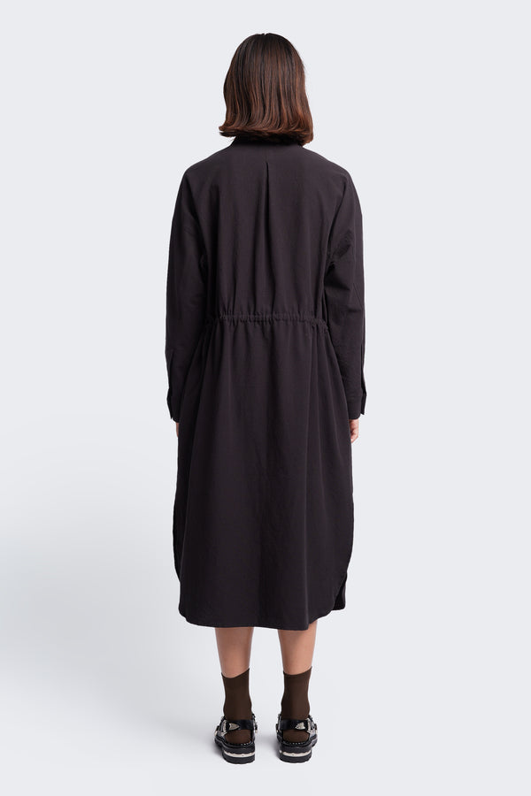The back of the Filter Dress Black made from 100% cotton. The long sleeve dress has waist ties to adjust the waistline to your liking.