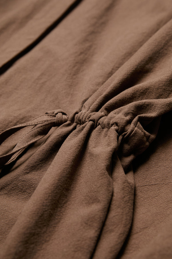 Close up of the waist ties on the Filter Dress brown. The waist ties allow you to adjust the shape to your liking. Made from 100% cotton.