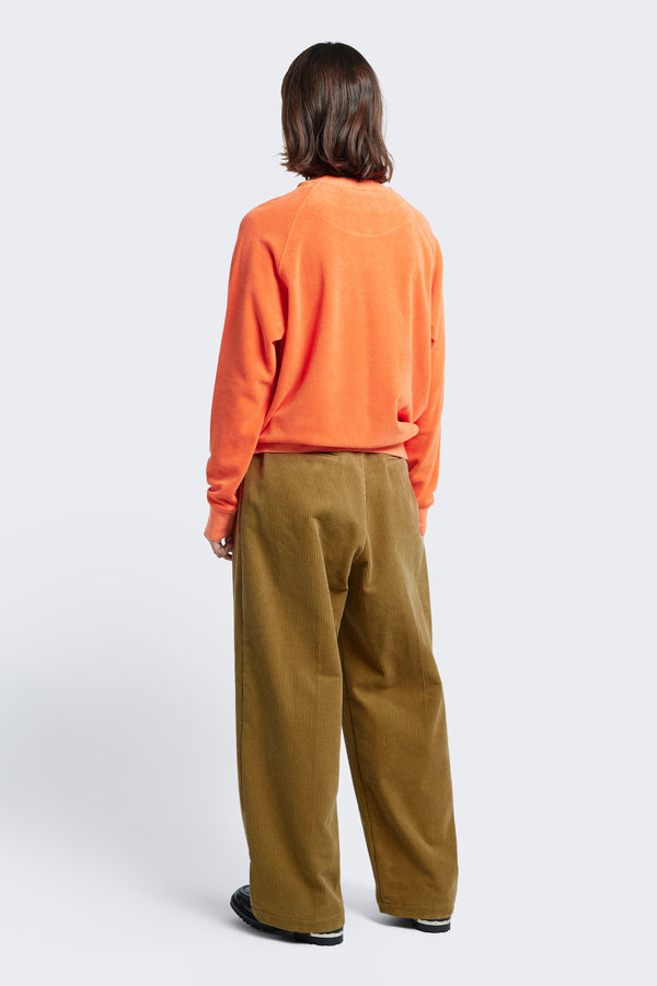 The back of Interim Pant Golden Tan, a semi-tailored cord pant two button-closing back pockets to keep valuables safe.