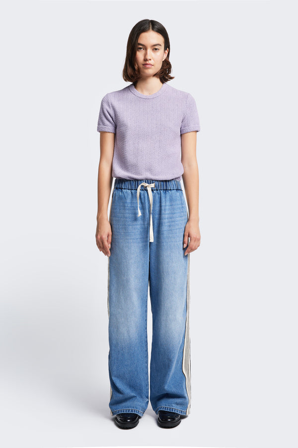 The Tribute Side Trim Pant is a casual wide leg pant with an elasticated waist and tie. Made from a soften cotton in a signature blue wash fade treatment.