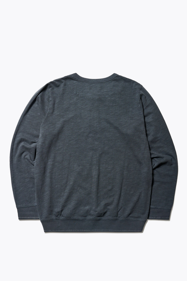 Back of The Asperse Henley in Black, featuring a three-button placket, ribbed cuffs and hem, and a garment pigment-dyed finish. Available in 5 sizes.