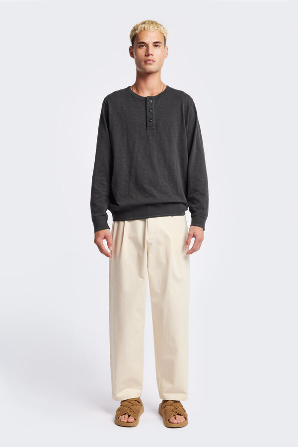 The Asperse Henley in Black, featuring a three-button placket, ribbed cuffs and hem, and a garment pigment-dyed finish. Available in 5 sizes.
