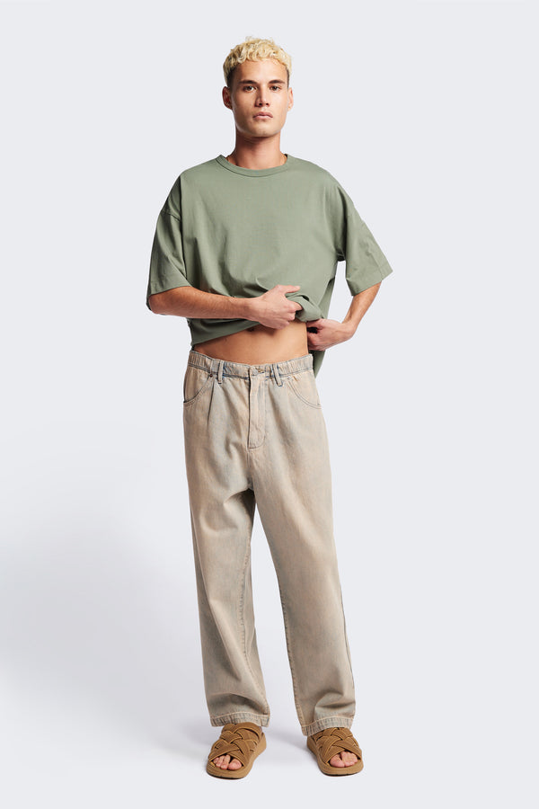 Front of the Fragment Pleat Denim Pant in Blue pink Fade, a relaxed fit and loose leg design, featuring an elasticated waistband, traditional denim front pockets, and patch back pockets. Available in 5 sizes.