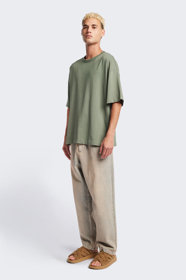 Side of the Fragment Pleat Denim Pant in Blue pink Fade, a relaxed fit and loose leg design, featuring an elasticated waistband, traditional denim front pockets, and patch back pockets. Available in 5 sizes.