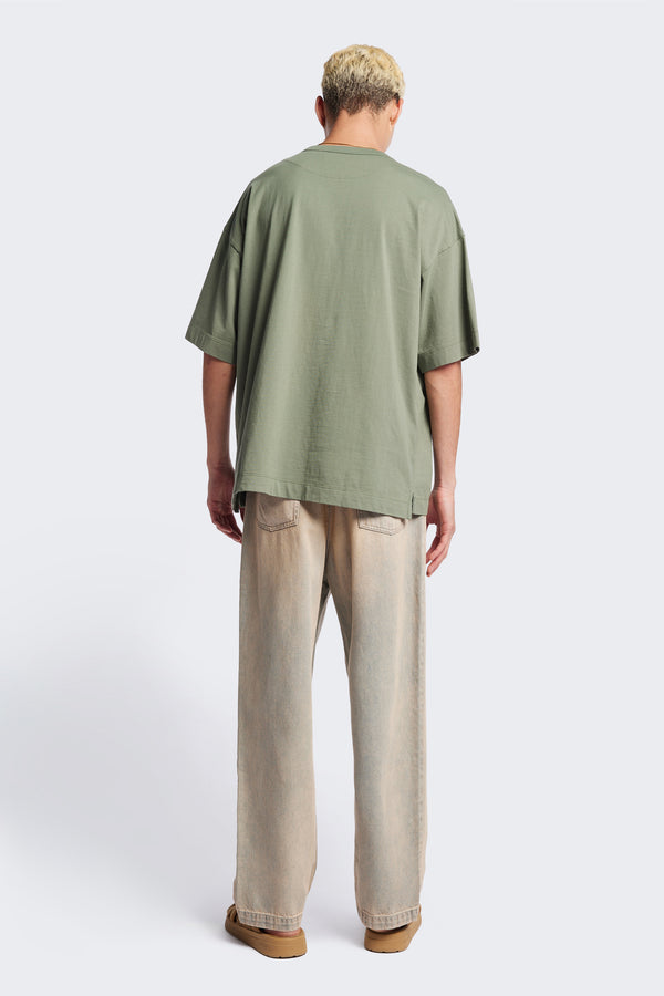 Back of the Fragment Pleat Denim Pant in Blue pink Fade, a relaxed fit and loose leg design, featuring an elasticated waistband, traditional denim front pockets, and patch back pockets. Available in 5 sizes.