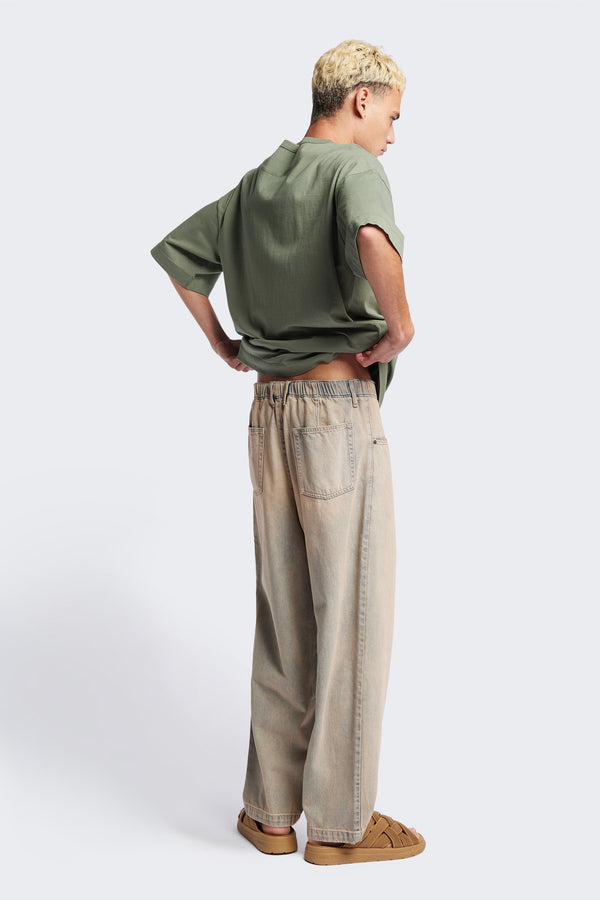 Back of the Fragment Pleat Denim Pant in Blue pink Fade, a relaxed fit and loose leg design, featuring an elasticated waistband, traditional denim front pockets, and patch back pockets. Available in 5 sizes.