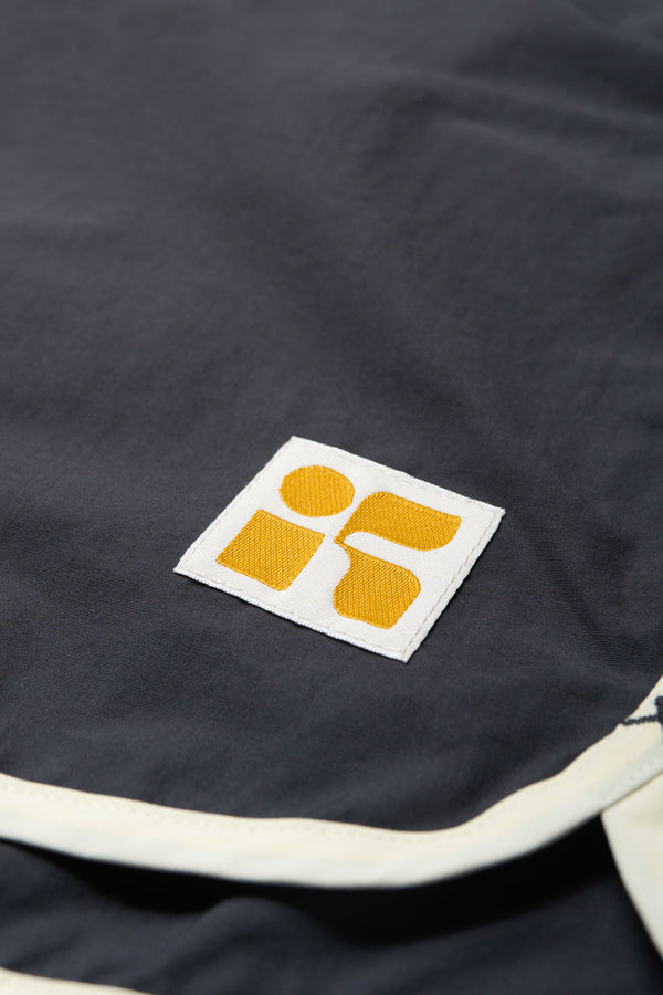 Close up details shot of The Hybrid Board short in Slate Grey, made from a functional technical cotton/nylon thats durable, stashable and quick-drying. Featuring back patch pocket with Velcro closure. Available in 5 sizes.