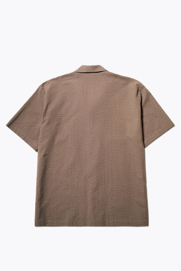 Back of The Mirari Shirt in Brown, a relaxed short-sleeve camp shirt in soft textured cotton seersucker with an open collar and laid-back fit, styled for versatile wear. Available in 5 sizes.