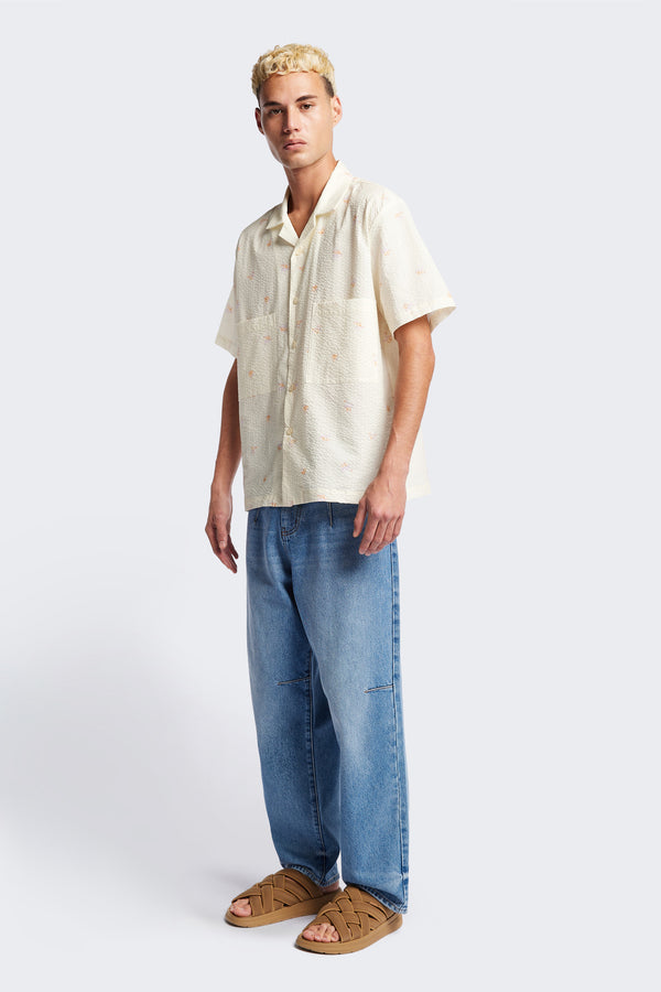 Front of the Mirari in Ecru floral, a relaxed short-sleeve open-collar camp shirt made from soft textured cotton seersucker, offering a laid-back fit. Available in 5 sizes.
