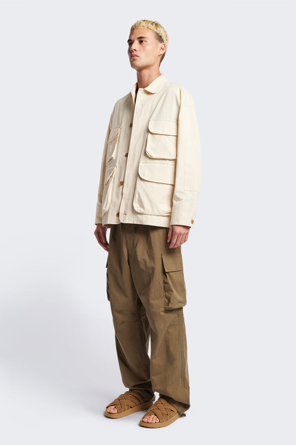 The Pressure Jacket in Chalk White, a relaxed boxy long sleeve jacket in washed cotton herringbone with 3D patch pockets and hidden zip openings. Available in 5 sizes.