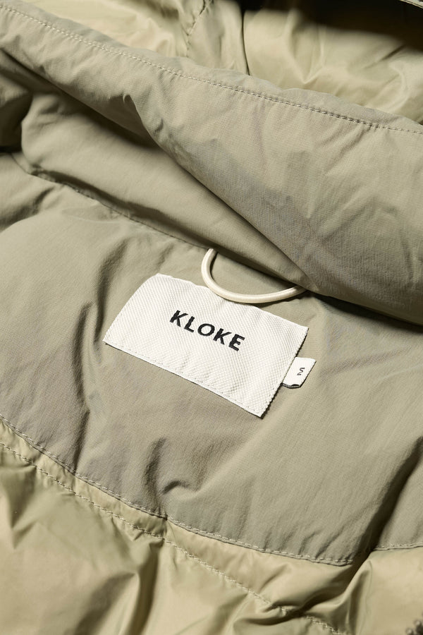 Close up inside detail shot of the Men’s Prospect Down Puffa a technical jacket with removable hood and utility pockets, made from recycled nylon. In Dusty Olive Green v