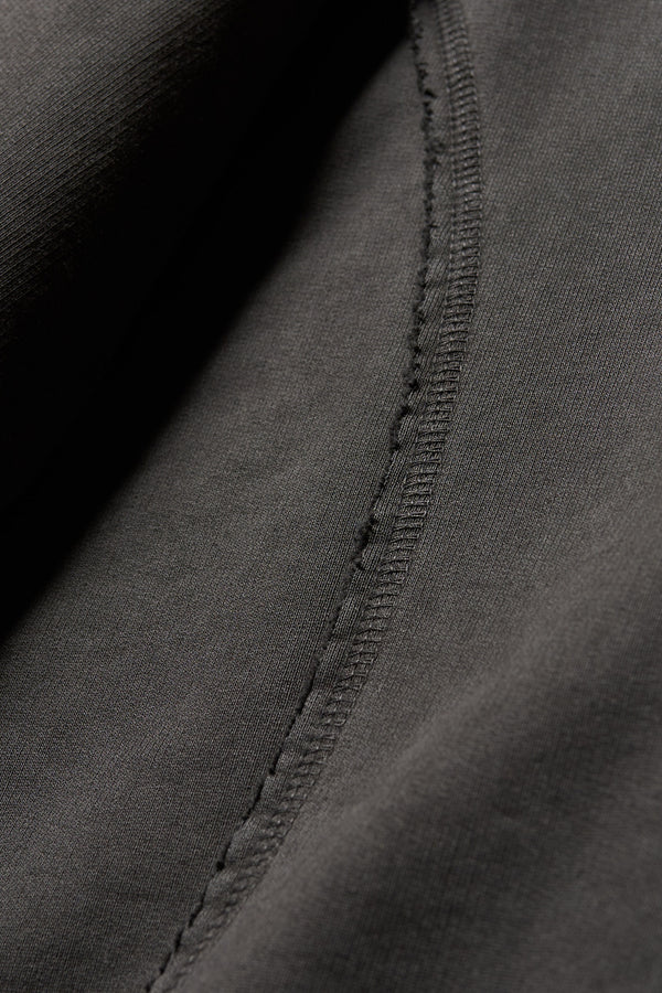 Close-up of raw flatlocked seams and blind-stitched finish on heavyweight unbrushed fleece on the Relic Hoodie in Jet Black
