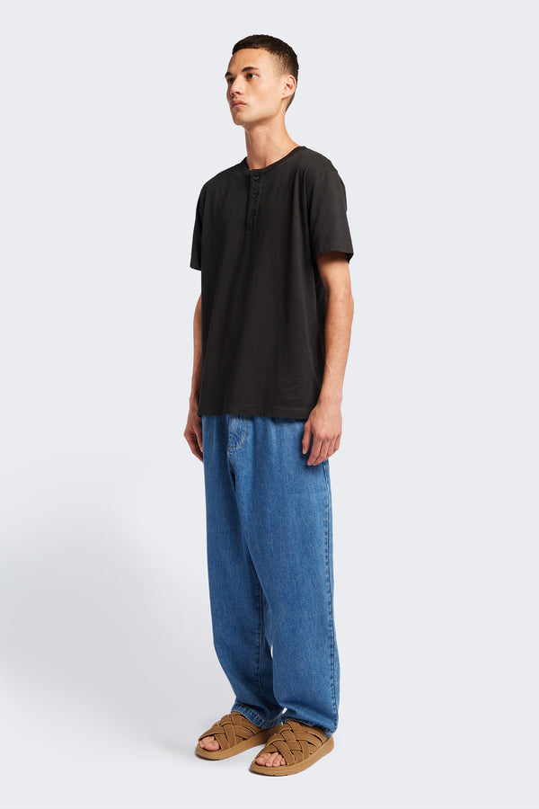 The Stratus Henley T-shirt in Vintage Black. Garment-dyed in soft cotton jersey with three-button placket and coverstitched hems. Available in 5 sizes.