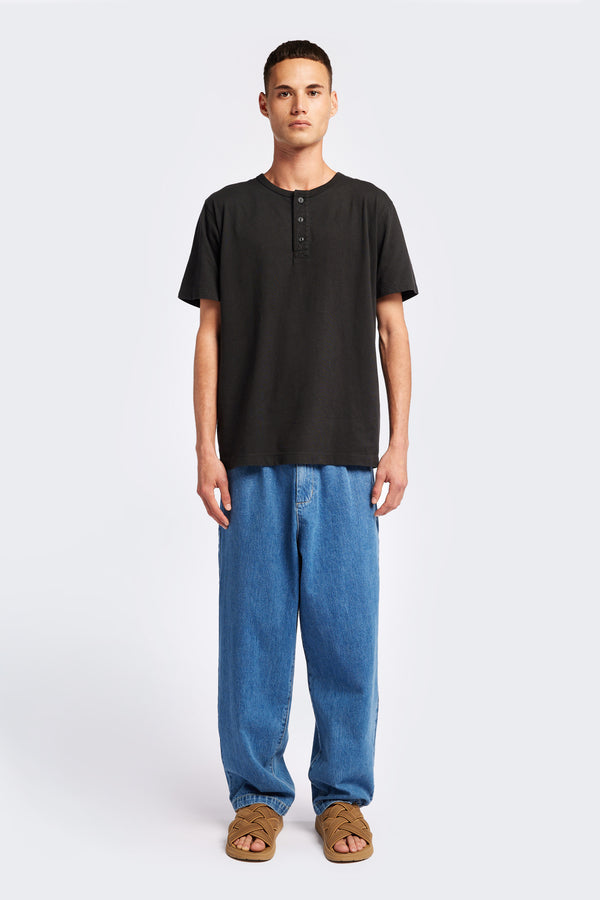 The Stratus Henley T-shirt in Vintage Black. Garment-dyed in soft cotton jersey with three-button placket and coverstitched hems. Available in 5 sizes.