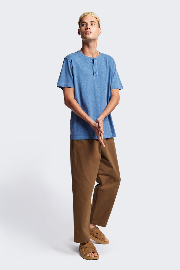 The Stratus Henley T-shirt in Blue. Garment-dyed in soft cotton jersey with three-button placket and coverstitched hems. Available in 5 sizes.