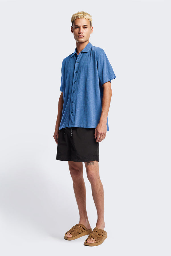 The Tectonic Shirt in blue, a classic boxy fit T-Shirt made from 100% cotton garment dyed jersey with a reinforced back yoke. Available in 5 sizes.