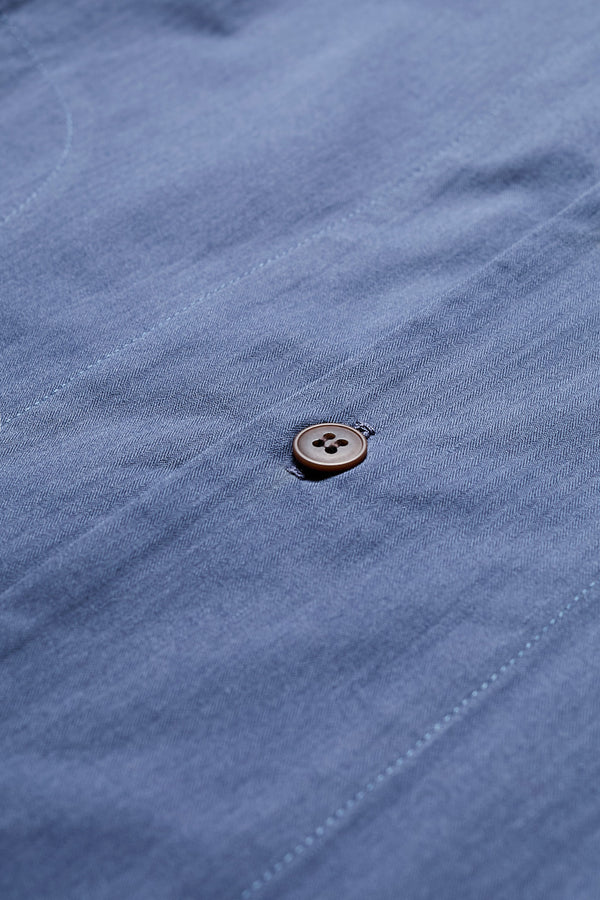 Close up details of the Blue Underground Long Sleeve Shirt in washed cotton herringbone twill with band collar and button placket. Available in 5 sizes.