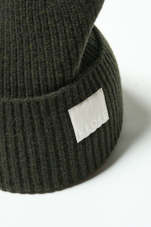 Close up fabric shot of ribbed knit beanie showing texture in Darkest Green