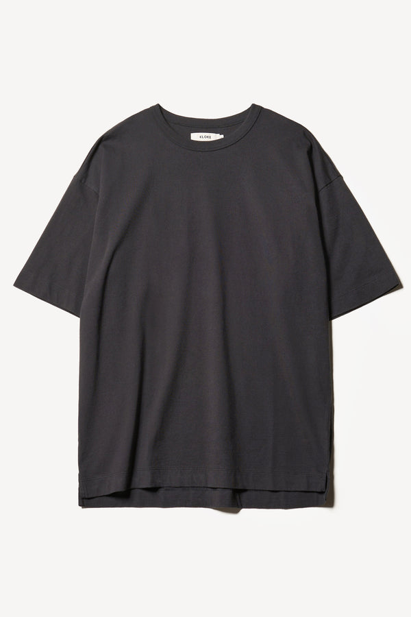 Flat Front of the Monolith Unisex Tee in Black. Oversized relaxed fit. Available in 6 sizes. Made from 100% Organic Cotton.
