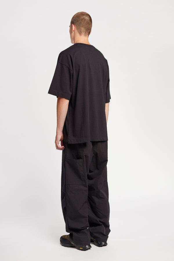 Men - back of model in Monolith Unisex Tee in Black. Oversized relaxed fit. Available in 6 sizes. Made form 100% Organic Cotton.