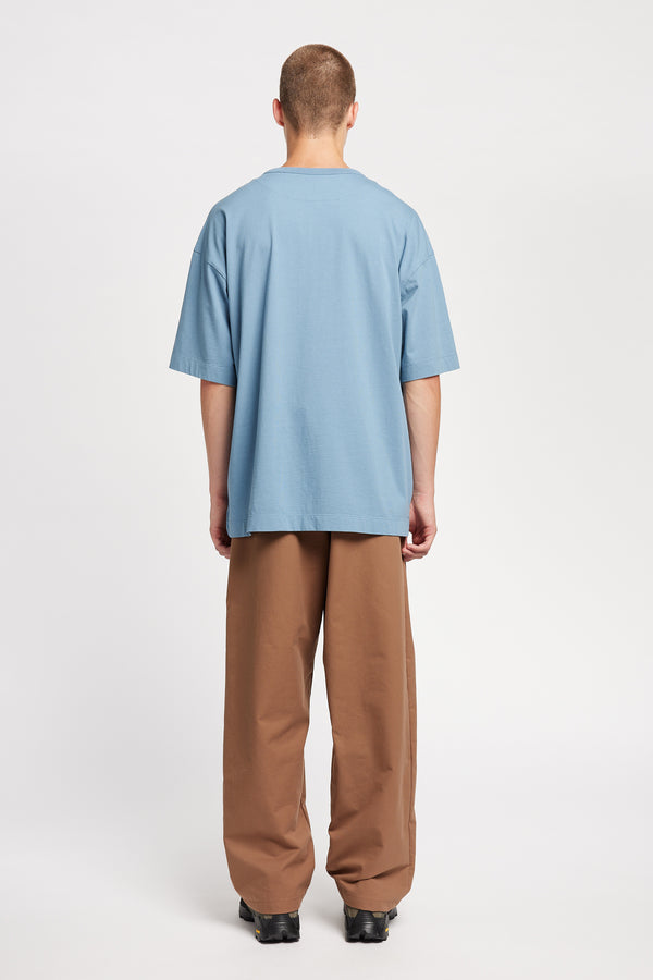 Men - back of model in Monolith Unisex Tee in Blue. Oversized relaxed fit. Available in 6 sizes. Made from 100% Organic Cotton