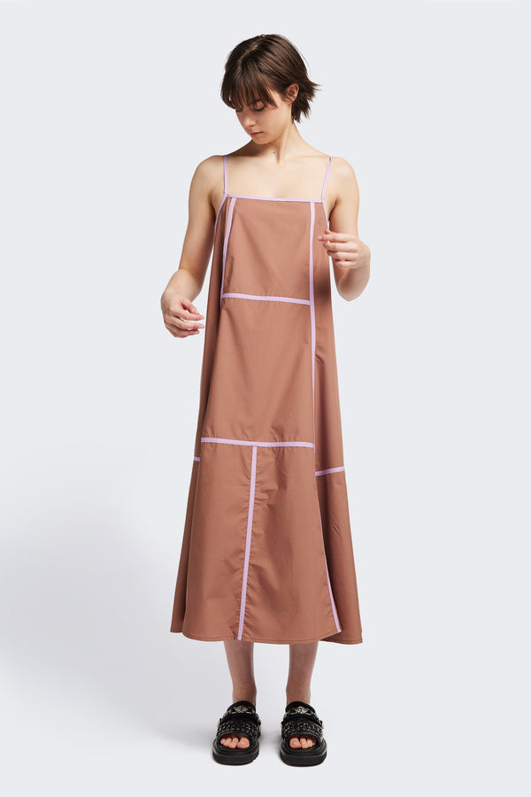 Front of the Adjourn Dress in brown/lilac, featuring contrasting block colours, bound seam details, adjustable thin straps, a straight neckline, and a flared A-line skirt. Available in 5 sizes.