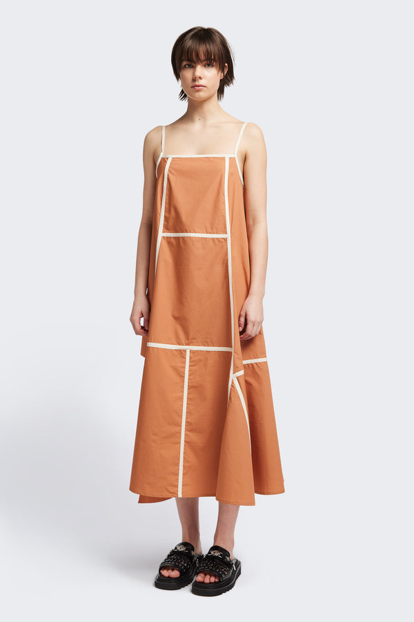 Front of the Adjourn Dress in burnt orange/ecru, featuring contrasting block colours, bound seam details, adjustable thin straps, a straight neckline, and a flared A-line skirt. Available in 5 sizes.