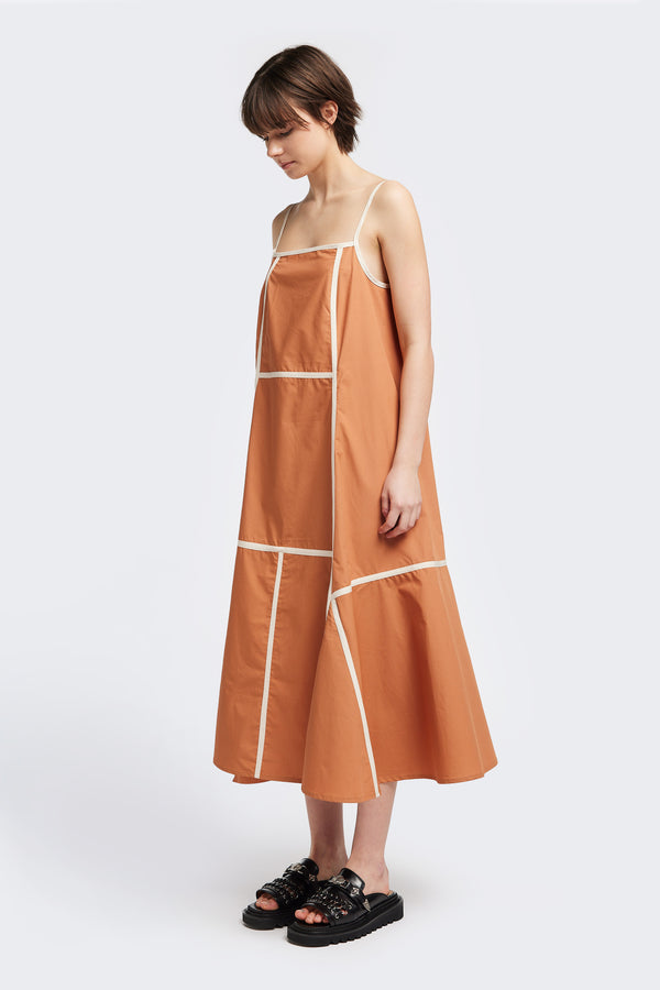 Front of the Adjourn Dress in burnt orange/ecru, featuring contrasting block colours, bound seam details, adjustable thin straps, a straight neckline, and a flared A-line skirt. Available in 5 sizes.