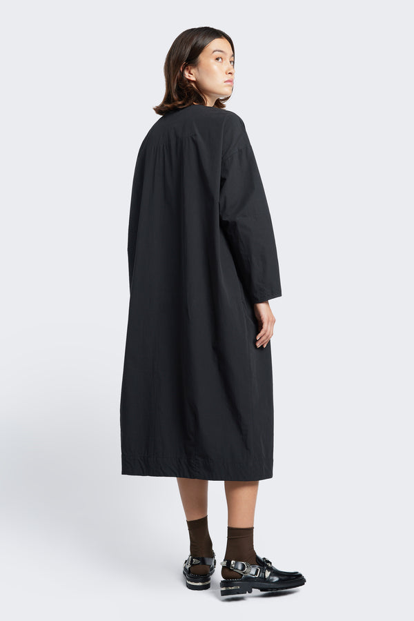The back of the Agora Dress Black with long sleeves and darted detailing along the back. Available in five sizes.