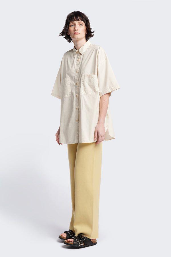 (women) Relaxed loose-fitting boxy short-sleeve shirt with back button placket, scoop hemline, and chest patch pockets, crafted in lightweight cotton poplin. Available in 5 sizes.