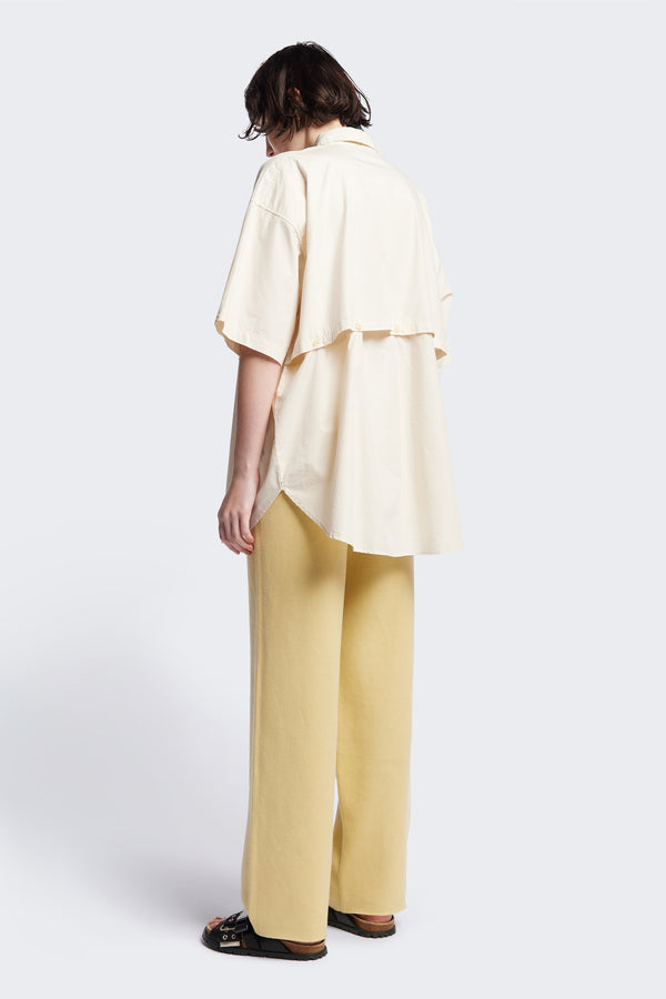 (women) Relaxed loose-fitting boxy short-sleeve shirt with back button placket, scoop hemline, and chest patch pockets, crafted in lightweight cotton poplin. Available in 5 sizes.