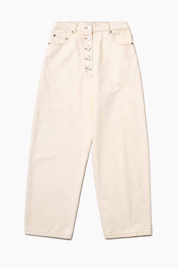 Flat Front of the Delphi Jean in ecru, featuring a wide leg that tapers at the ankle, with an exposed button fly and Kloke-branded hardware. Available in 10 sizes.