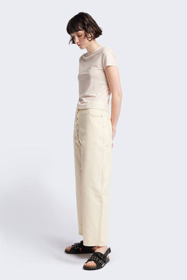 Side of the Delphi Jean in ecru, featuring a wide leg that tapers at the ankle, with an exposed button fly and Kloke-branded hardware. Available in 10 sizes.