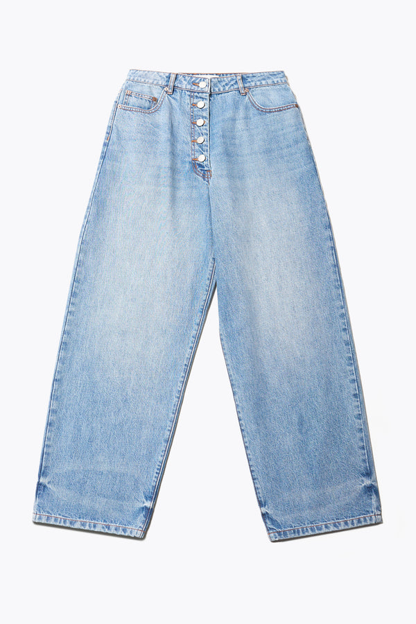 Flat Front of the Delphi Jean in mid blue fade, featuring a wide leg that tapers at the ankle, with an exposed button fly and Kloke-branded hardware. Available in 10 sizes.