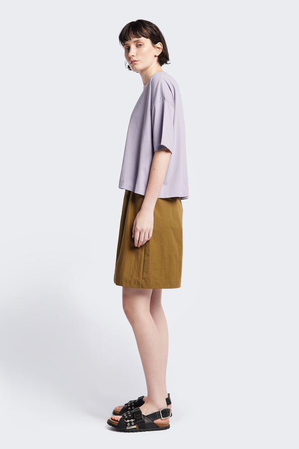 Side view of Tailored Depth Short in Olive Brown, crafted from soft cotton with pleat front detail, slant pockets, and a relaxed wide leg. Finished with back dart detailing and patch pockets. Available in 6 sizes.