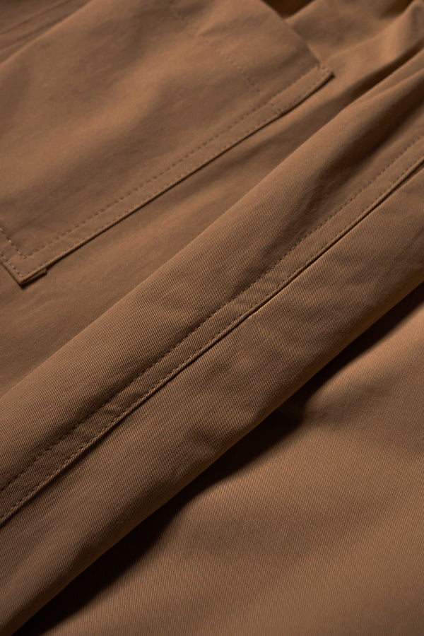 Close up fabric shot of the Factor Pleat Pant in Brown. A relaxed-fit pants with an encased elastic waistband, darted hem detail, side entry pockets, and back patch pockets. Comfortable and perfect for summer. Available in 6 sizes.