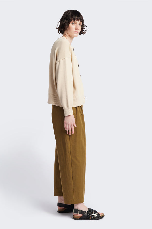 Side view of the Flow Cardigan in Ecru Beige , relaxed boxy cardigan in soft cotton yarn with a crew neckline, button closure, and exaggerated dropped shoulders. Available in 5 sizes.