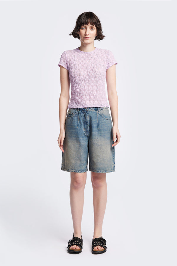 The Fuego Longline denim shorts in a blue fade with a subtle pink tint, featuring darted waist details and a relaxed wide-leg design. Available in 6 sizes.