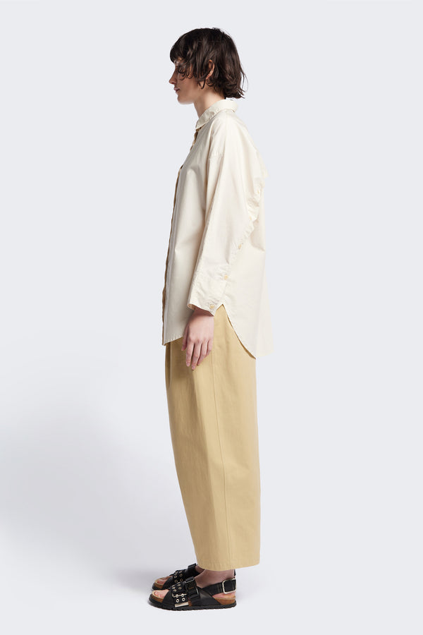 Side of the Kestrel Shirt Ecru – relaxed long sleeve shirt with back button placket and scoop hemline, worn by model. Available in XXS, XS, S, M, L