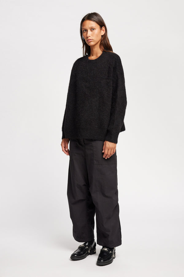 Front angle view of Model wearing alpaca blend Laurel Crew Neck Knit Sweater in black