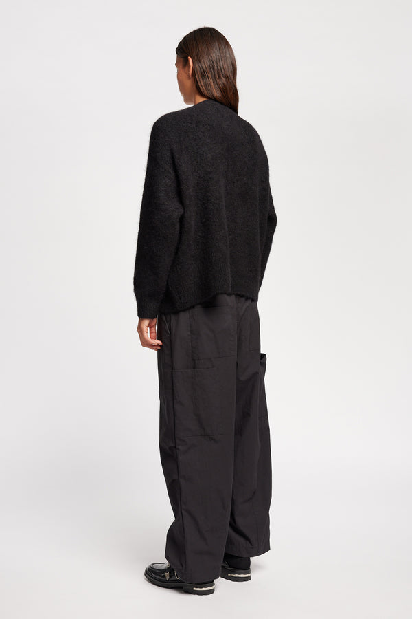 Back angle view of Model wearing alpaca blend Laurel Crew Neck Knit Sweater in black