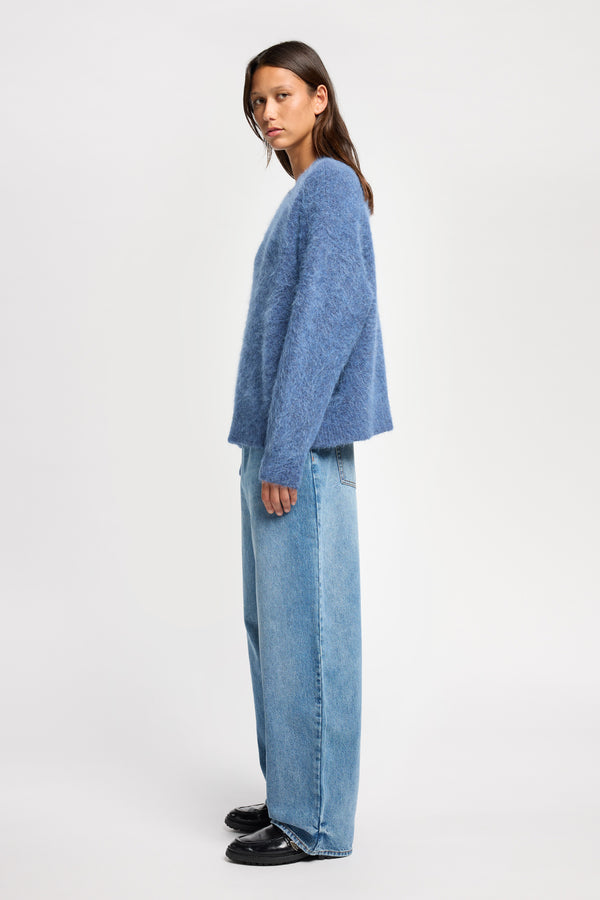 Side view of Model wearing alpaca blend Laurel Crew Neck Knit Sweater in indigo marle