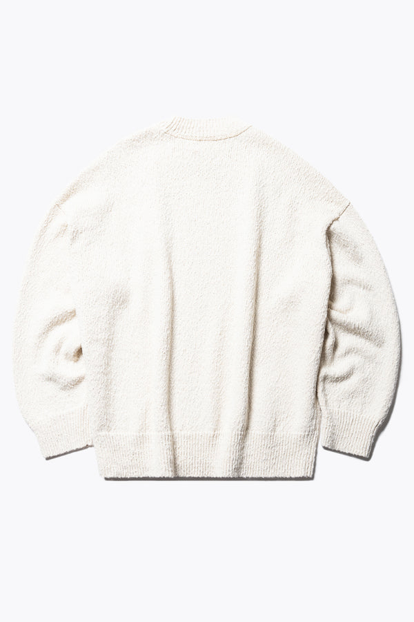 Flat back of the Ecru Leeway Sweater in a soft chunky cotton knit, featuring an oversized relaxed fit, raglan sleeves, and ribbed hem and cuffs.
