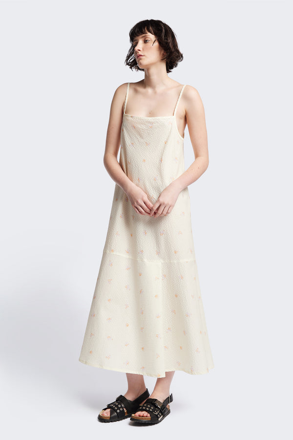 The Natant Dress in ecru floral, a Maxi-length Natant Dress with adjustable thin straps, a straight neckline, and a bias-cut silhouette, made from lightweight printed seersucker. Available in 5 sizes.