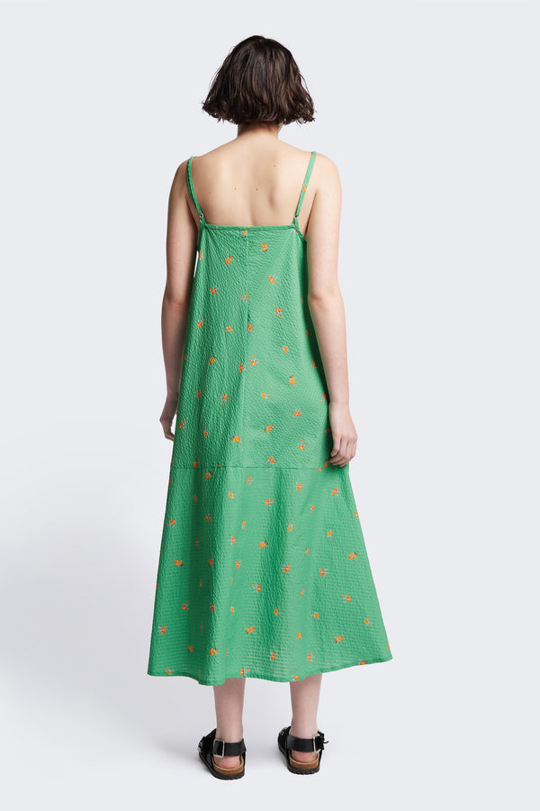 back of The Natant Dress in green floral, a Maxi-length Natant Dress with adjustable thin straps, a straight neckline, and a bias-cut silhouette, made from lightweight printed seersucker. Available in 5 sizes.