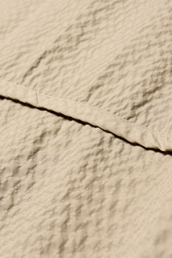 Close up of the Omit top in Japanese nylon seersucker top in Stone/ beige with dropped sleeves and a round neckline.