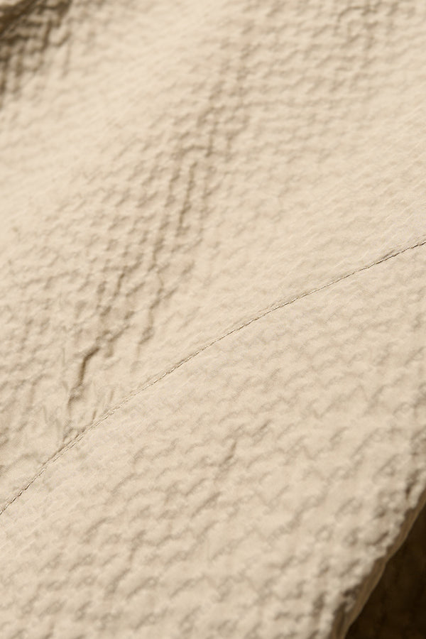Close up fabric detail shot of the Parapet Dress in Stone/beige lightweight seersucker nylon.